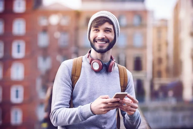 Uśmiechnięty mężczyzna z komórka w dłoniach